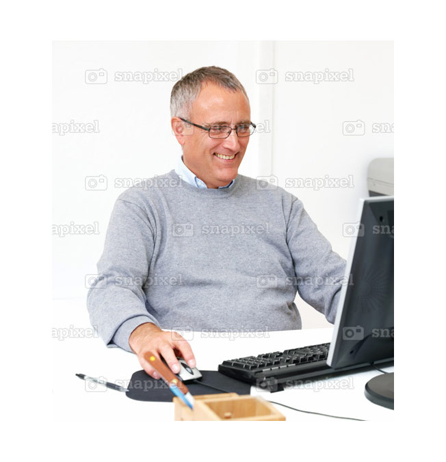 stock photo of casual man working on computer and smiling