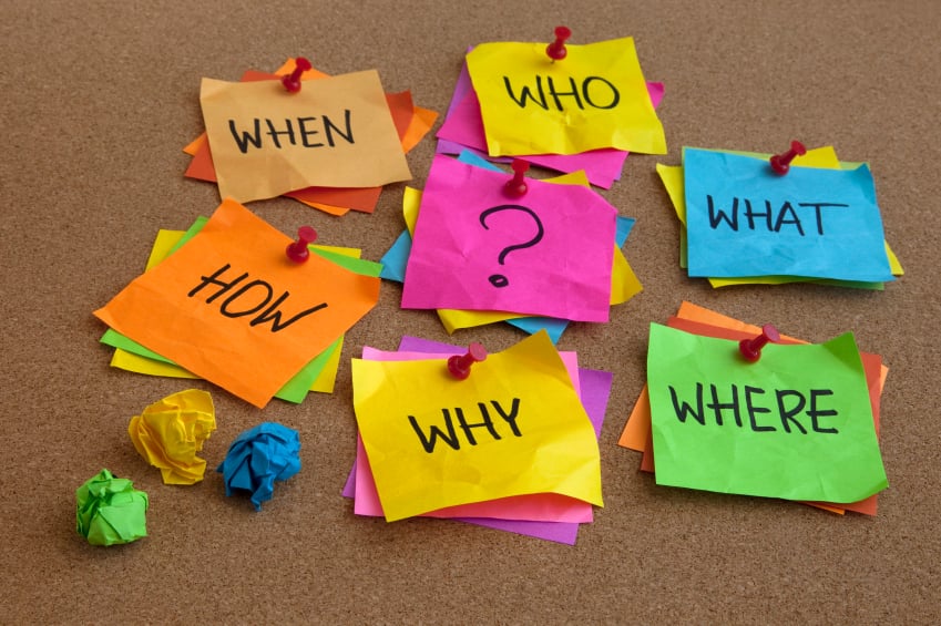 who, what, where, when, why, how questions - uncertrainty, brainstorming or decision making concept, colorful crumpled sticky notes on cork bulletin board