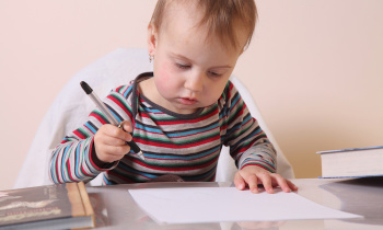 Little beautiful girl writing in her book