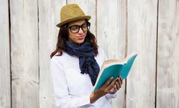 Smiling hipster woman reading a book