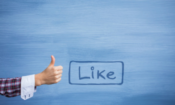 Hand showing thumbs up gesture and like button