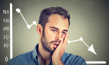 frustrated stressed young man desperate with financial market chart graphic going down