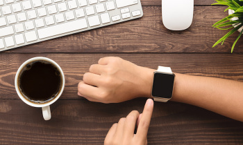 hand using smartwatch on desk top view