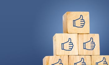 Thumb up icon on wood cube at dark blue background, leave space for adding text