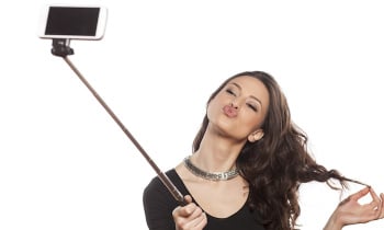 pretty brunette making selfie with a stick