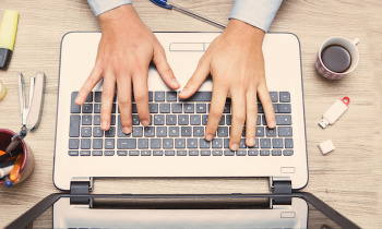 mani di uomo al alvoro sulla tastiera di un notebook informatico
