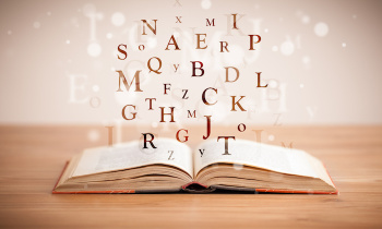 Opened book with flying letters