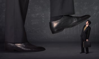 Huge leg stepping on a tiny businnessman concept