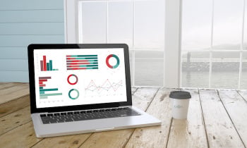 laptop with graphics on screen with port background and coffee