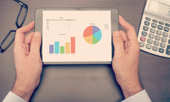 Businessman checking statistics on tablet device
