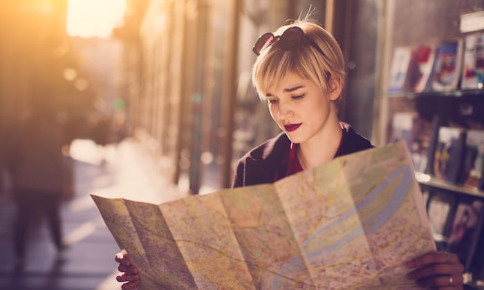 Google Maps Marketing Guide: Image of woman looking at a paper map 