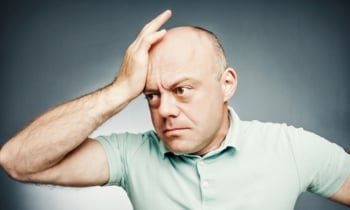 middle-aged man put his hand to his head complains, with shocked facial expression