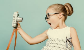 child holding a instant camera