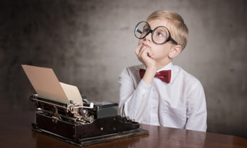 Dreaming boy with old typewriter. Retro style portrait