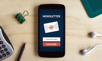 Subscribe newsletter concept on smart phone screen on wooden desk