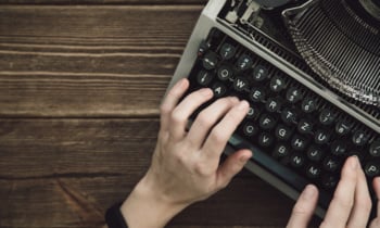 Writer typing with retro writing machine.