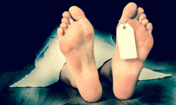 Dead woman lying on the floor under white cloth
