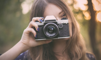 Pretty girl with vintage camera in park