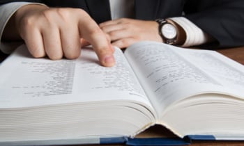 man looking in the large dictionary