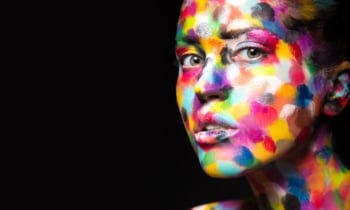 Girl with colored face painted. Art beauty image.