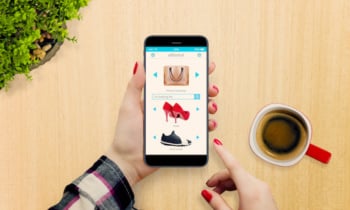 Female hands with modern phone in hands on the table, top view. Shopping online concept.