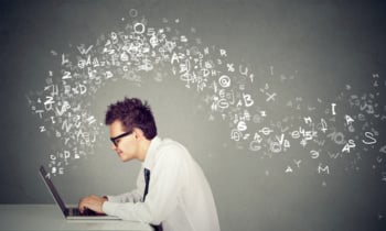 Young man typing on laptop computer alphabet letters flying away