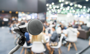 Microphone with abstract blurred photo of conference hall or seminar room with attendee and bokeh, Business meeting concept