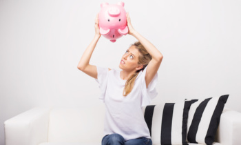 Woman looking for money in piggy bank
