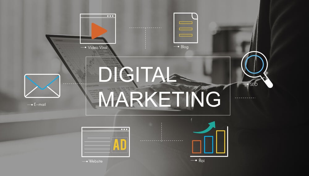 digital marketing escrito em frente a laptop com icones de lupa, documentos, graficos entre outros