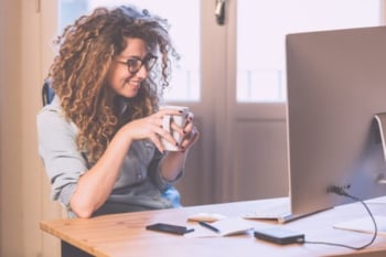profissional sorridente em frente a computador ilustrando o que é segmentação de mercado