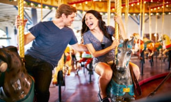 romantic couple riding carousel together on date