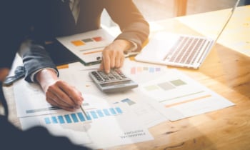 Consult financial concept. Business man pointing at papwework and using laptop computer.