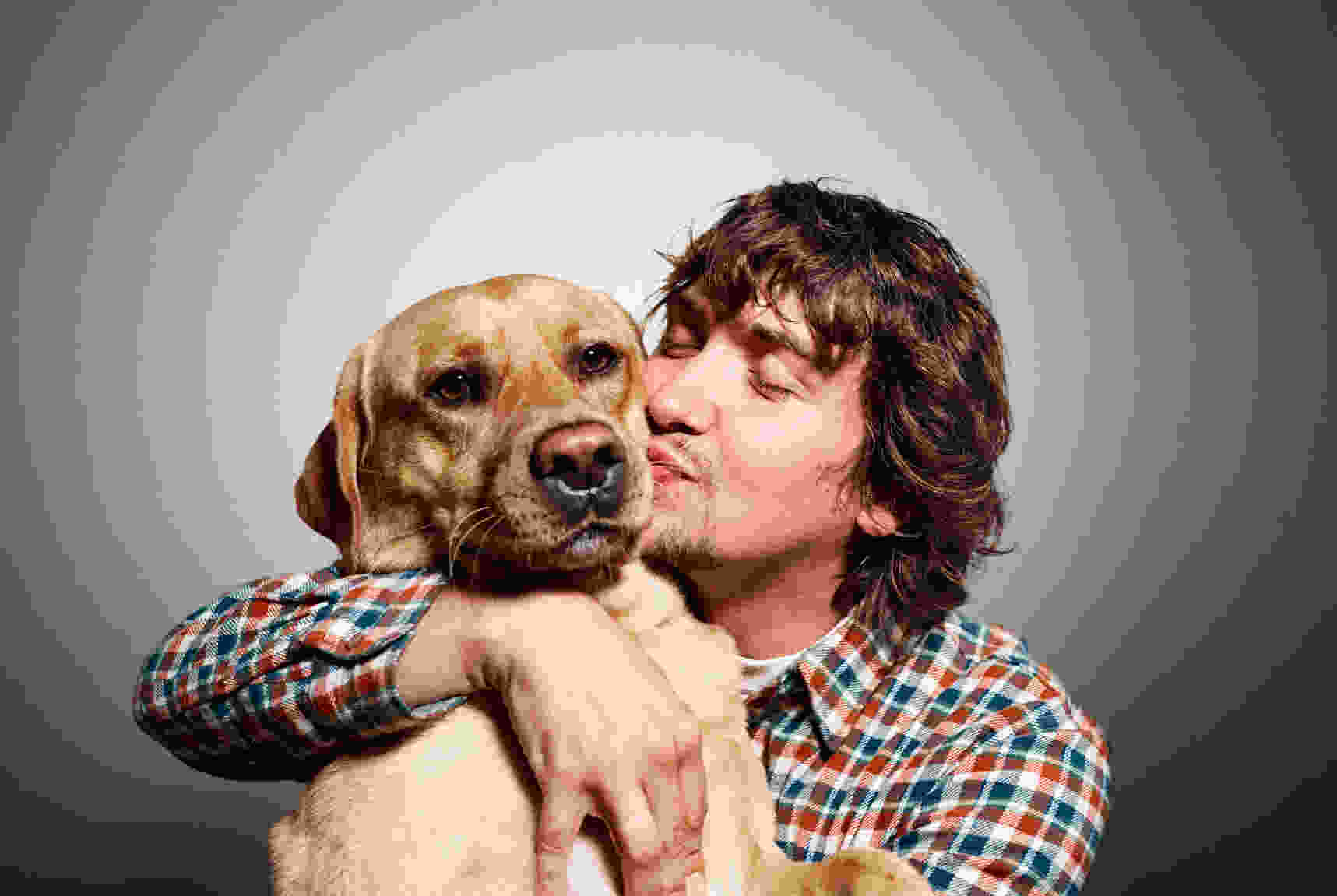 blurry compressed image of man kissing dog