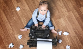 Little boy sitting at typewriter