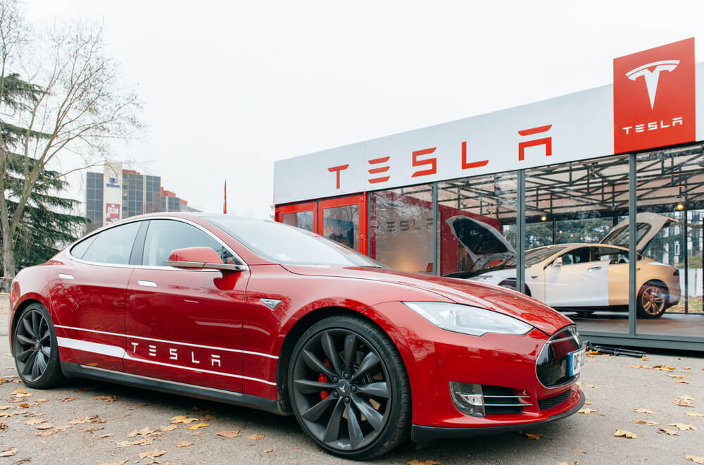 automóvel e fachada da empresa Tesla