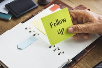 cadernos de anotação em mesa e o título follow-up em papel amarelo