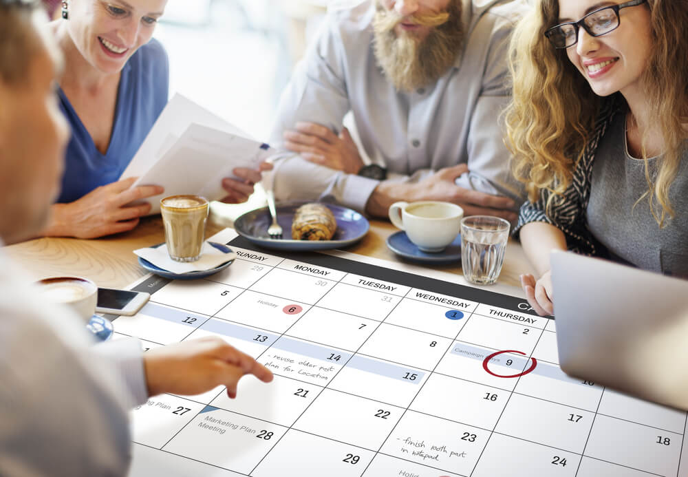 equipe organizando evento com calendário em mesa