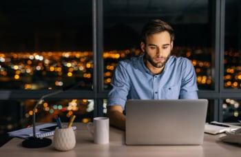 homem concentrado em trabalho onlin em laptop