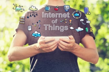 homem segurando smartphone com ilustração sobre Internet das coisas