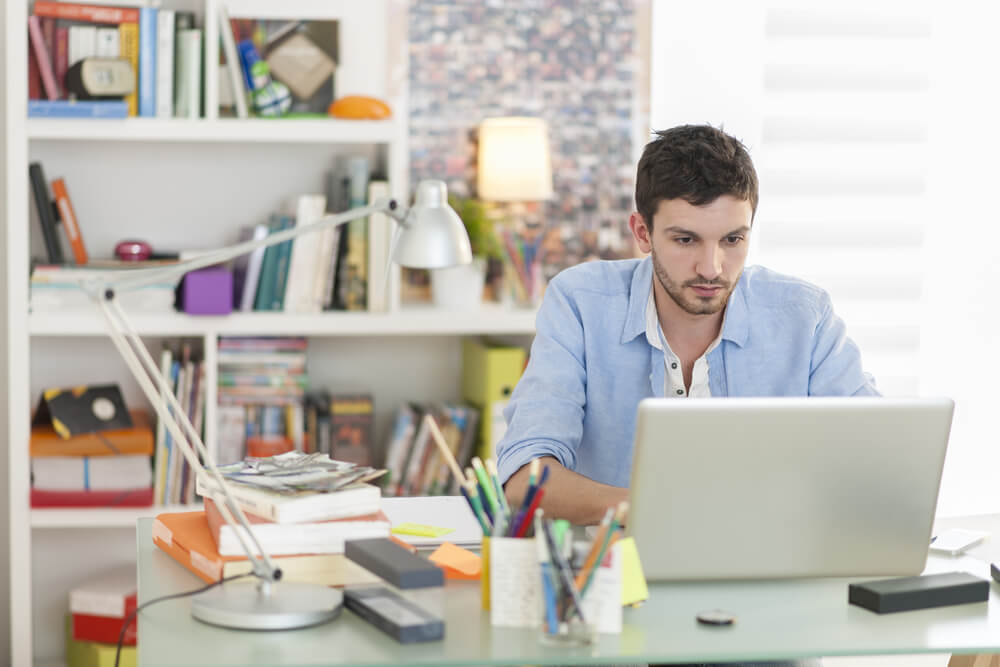homem trabalhando em laptop em home office