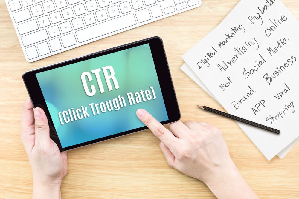 mesa de escritório com pessoa acessando tablet com conteúdo sobre CTR 