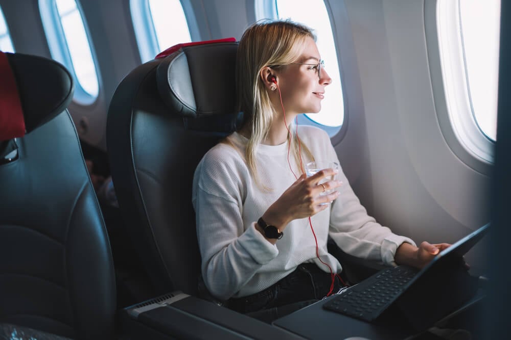 moça acessando laptop no avião