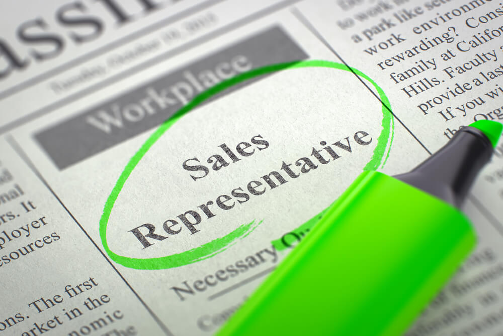 página de jornal junto de marcador verde circulado o título Sales Representative