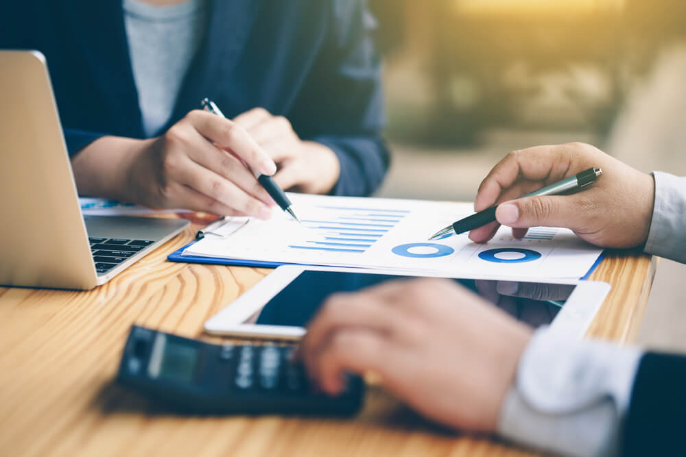 planilhas e graficos financeiros juntos de calculadora e laptop