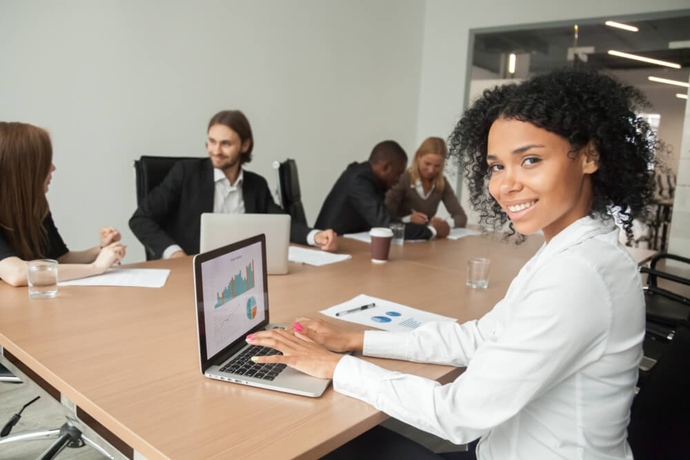 profissional acessando planilhas no laptop em reunião de equipe