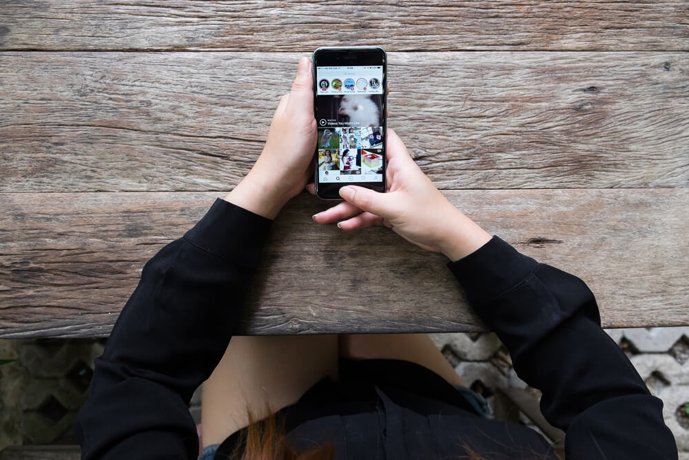 mulher segurando o celular mostrando instagram stories