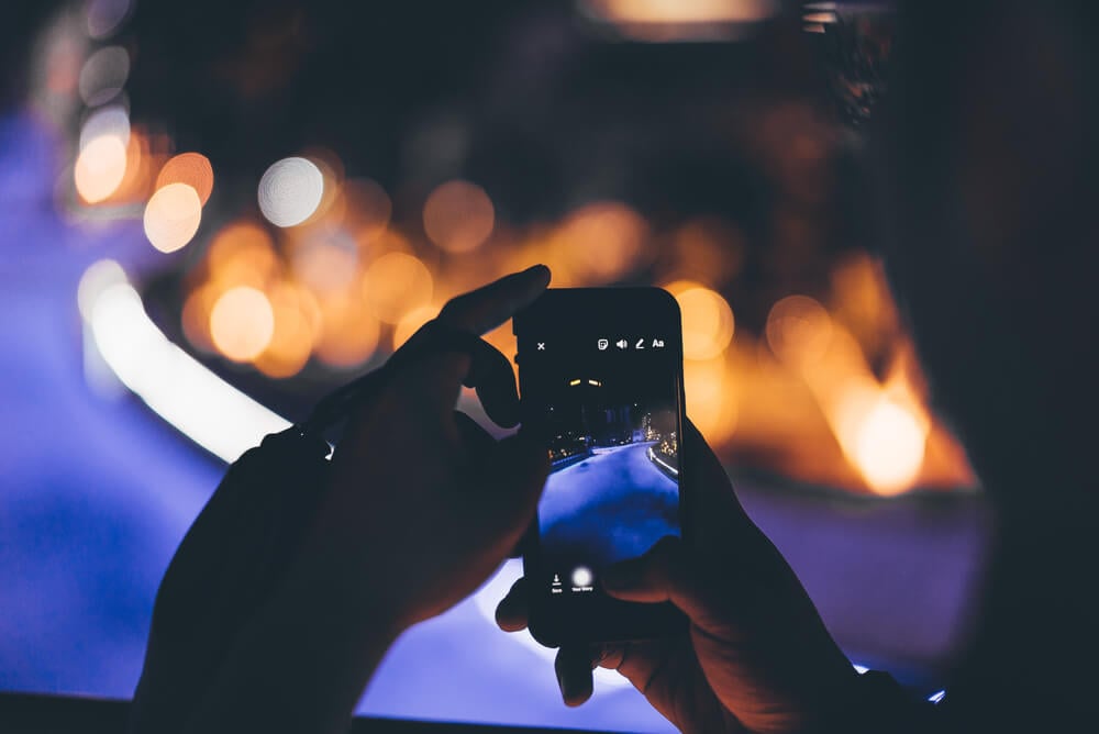 pessoa tirando foto noturna com o celular