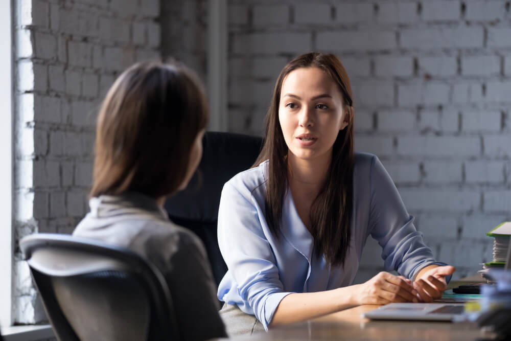 comunicaçao entre duas mulheres em escritorio