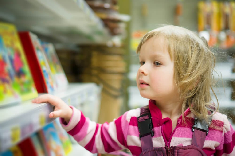 criança curiosa em supermercado indicando os impactos da publicidade infantil