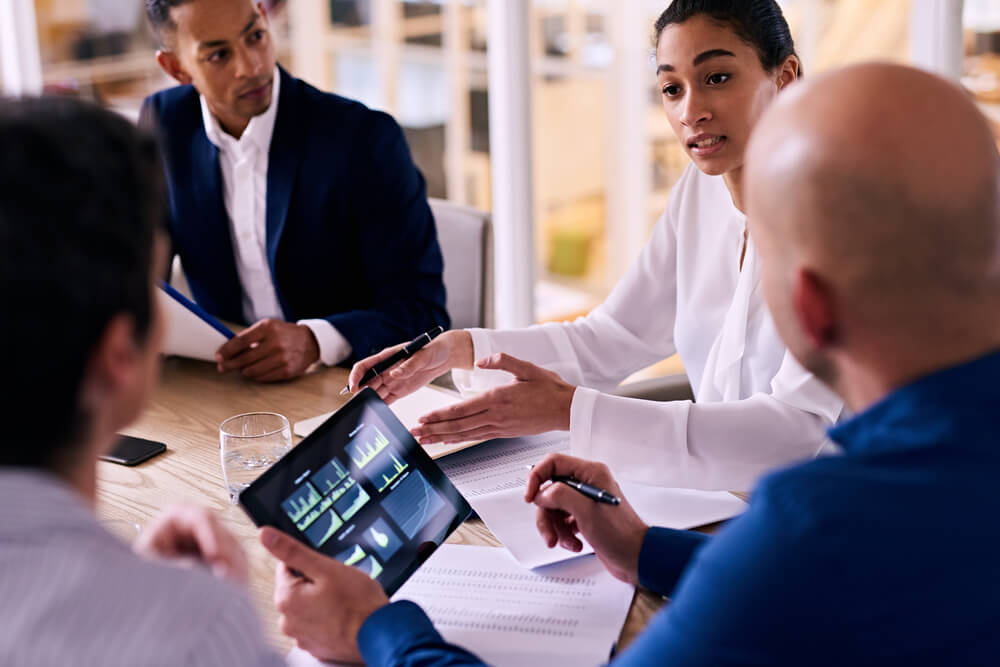 equipe analisando gráficos de crescimento em mesa de reuniões